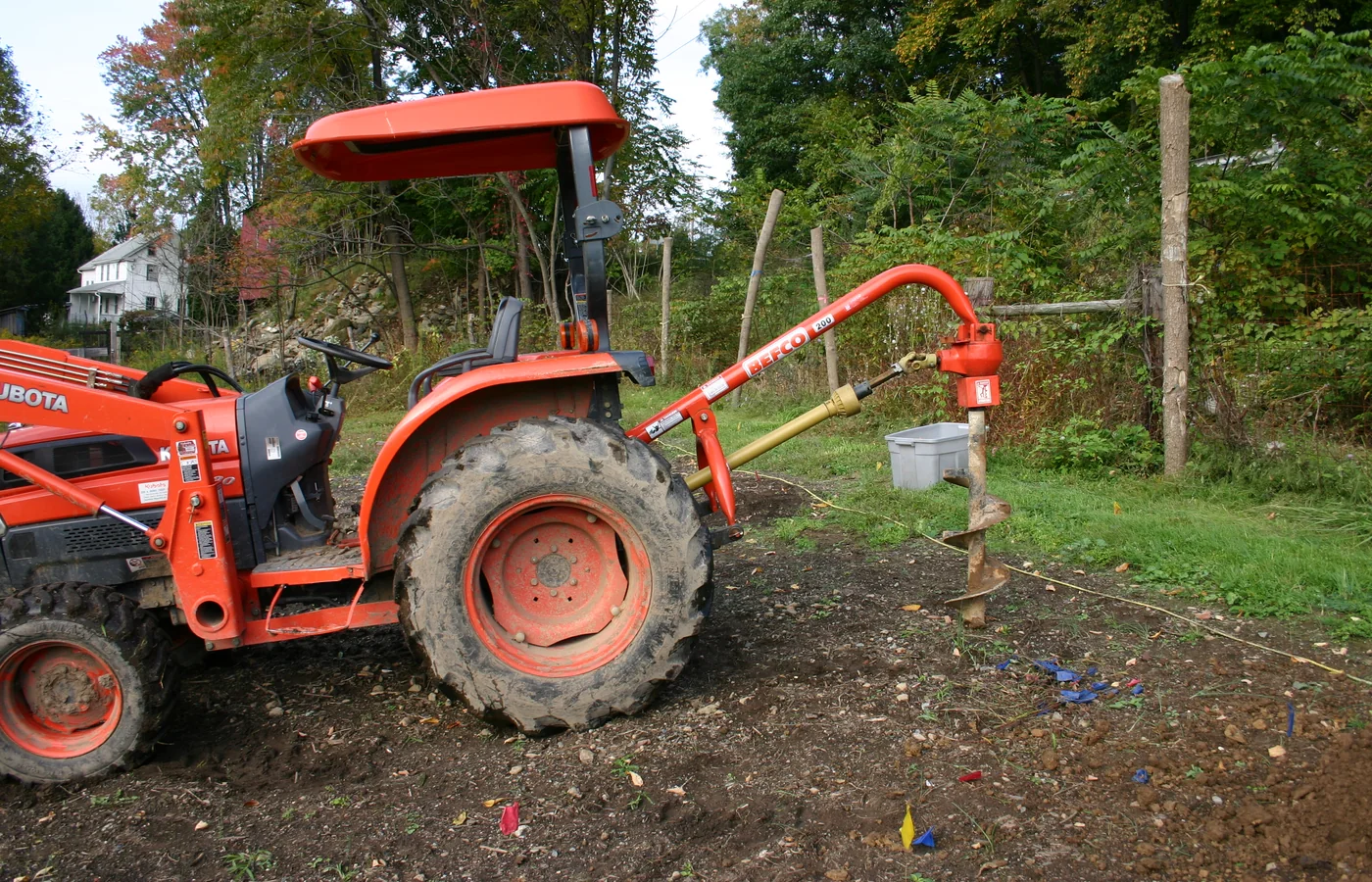 Compact tractor fitted with a three-point post-hole auger