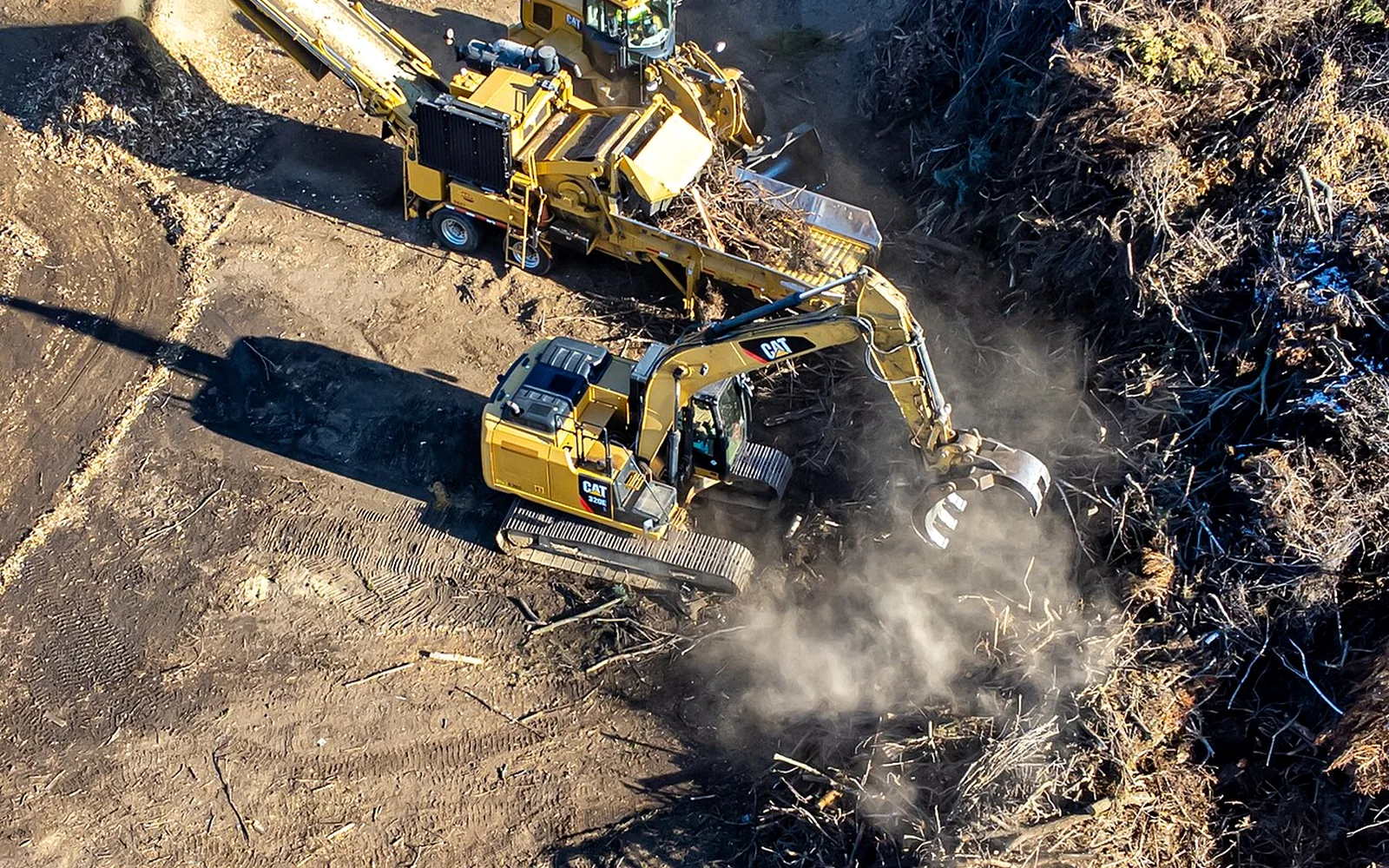 Aerial view of excavators using grapples in a demolition and material processing yard