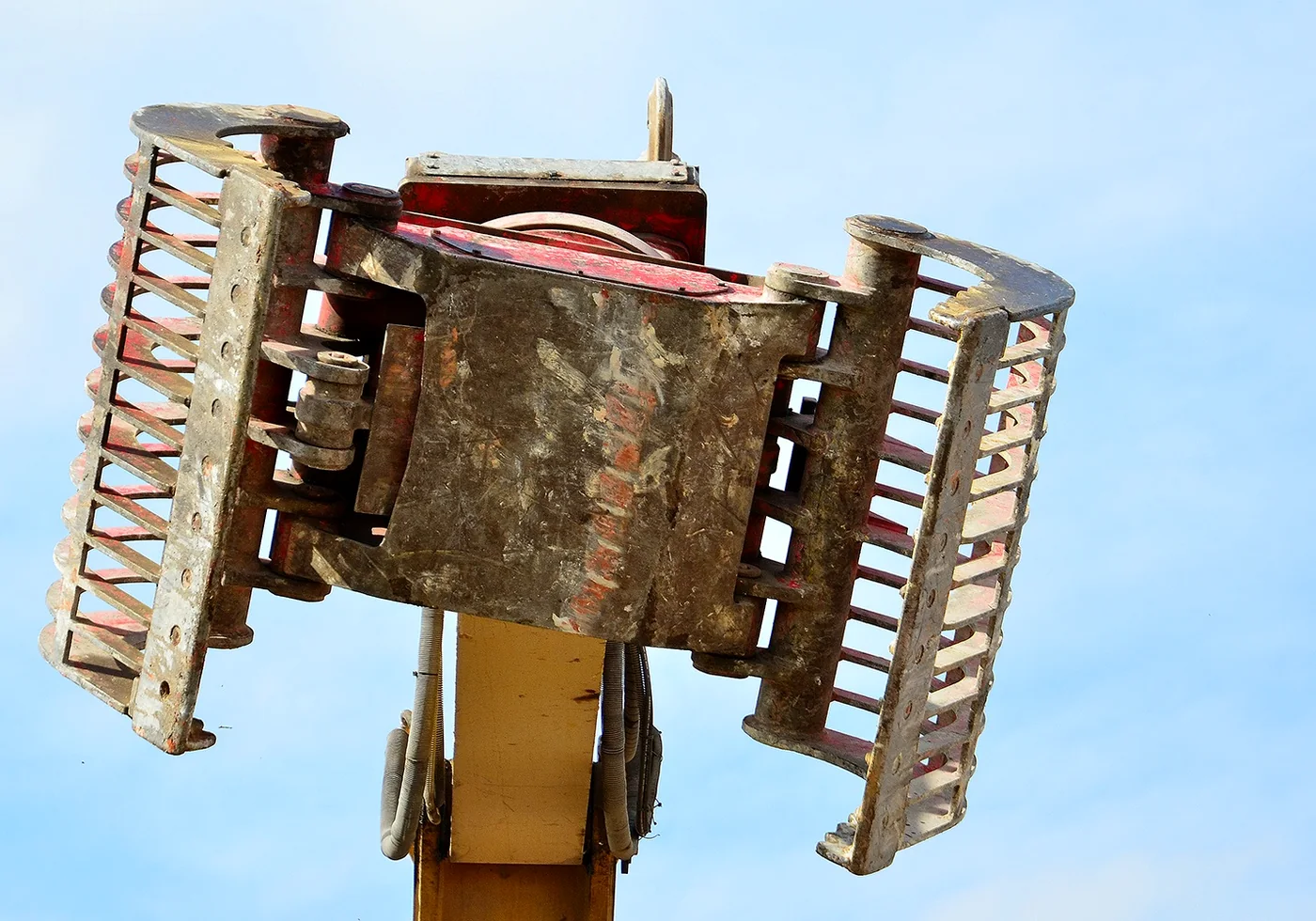 Close-up from below of an open demolition grapple showing shells, pivots and rotator