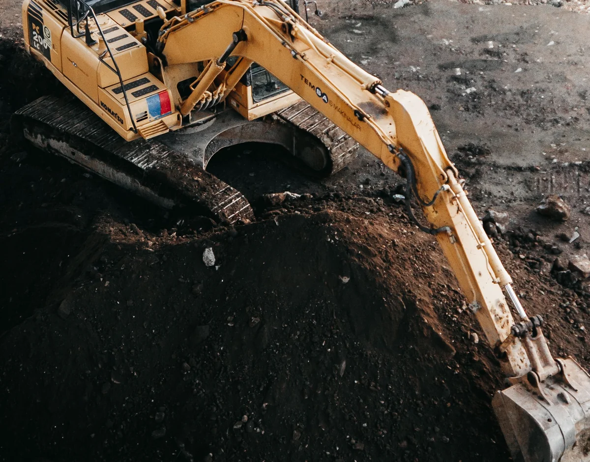 High-angle view of an excavator digging and handling dense soil