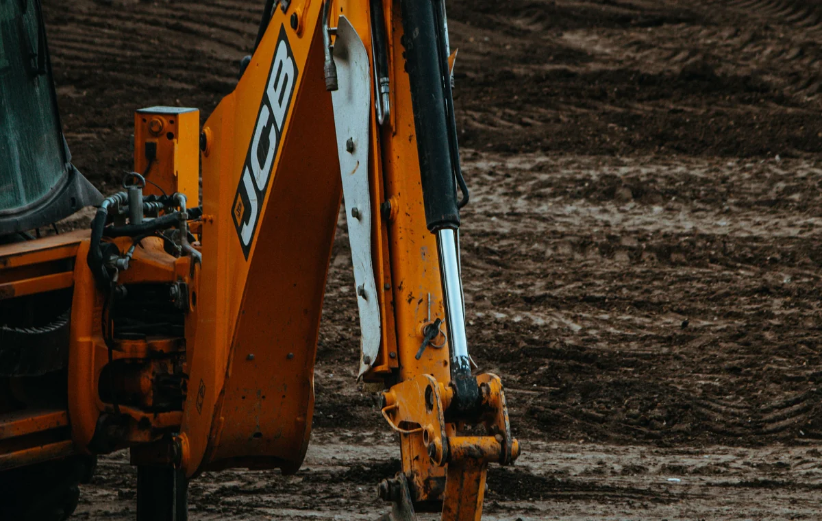 Backhoe bucket working in wet soil during excavation