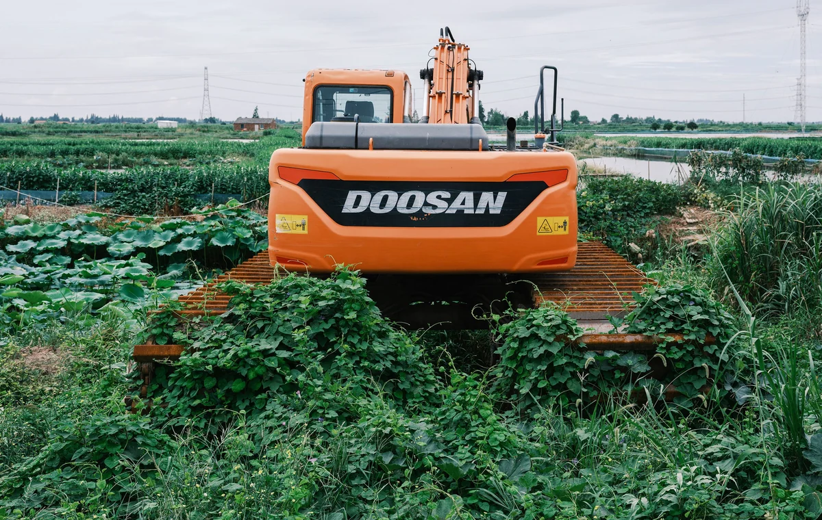 Excavator operating in a field during landscaping and land preparation