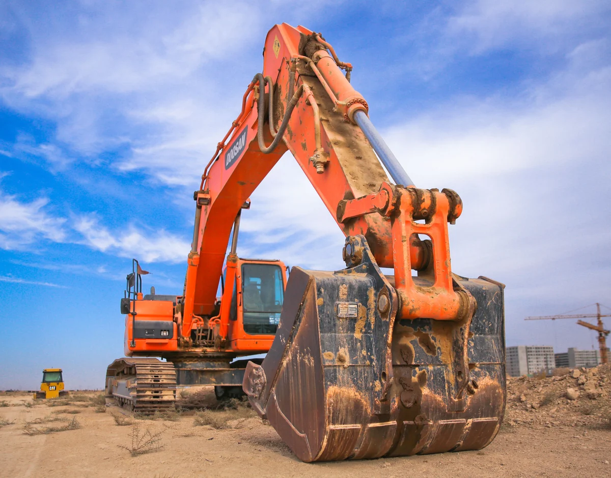 Excavator and bucket positioned on a construction site before grading work