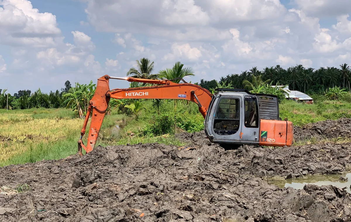 Excavator working in soft ground during drainage and land preparation