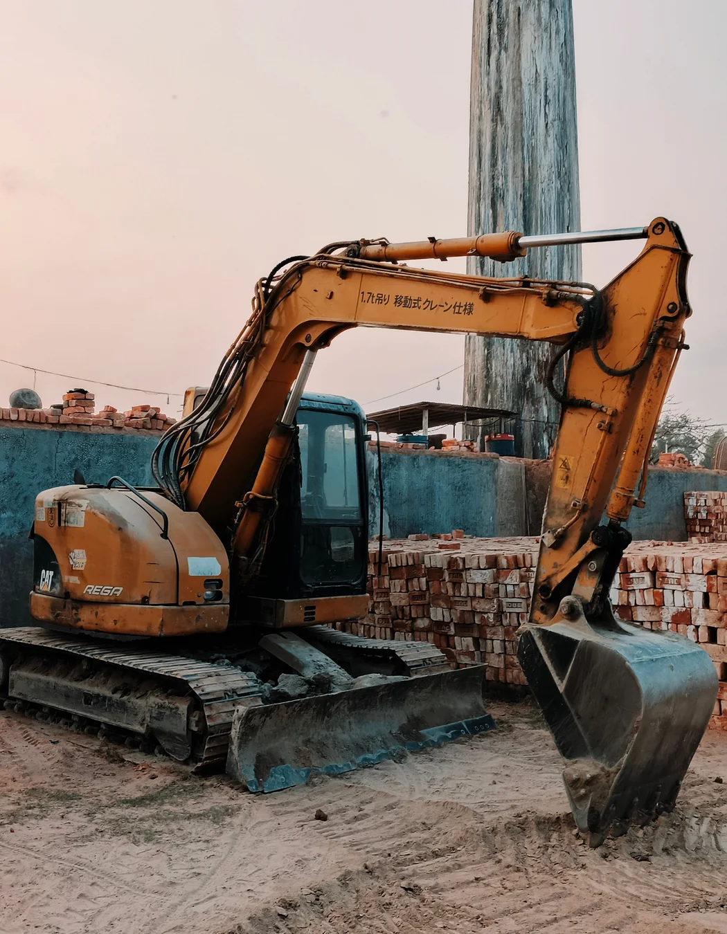 Compact tracked excavator on a confined construction site, representing smaller carrier installations