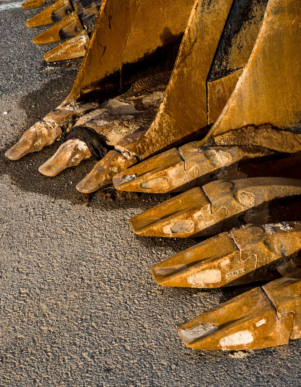 Close-up of excavator bucket teeth and replaceable wear components