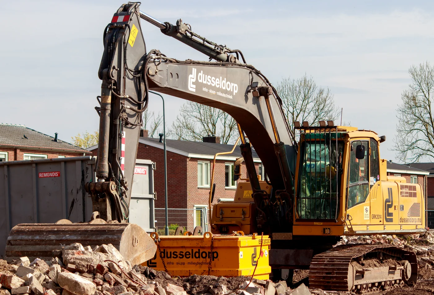 Tracked excavator working on broken masonry and demolition rubble