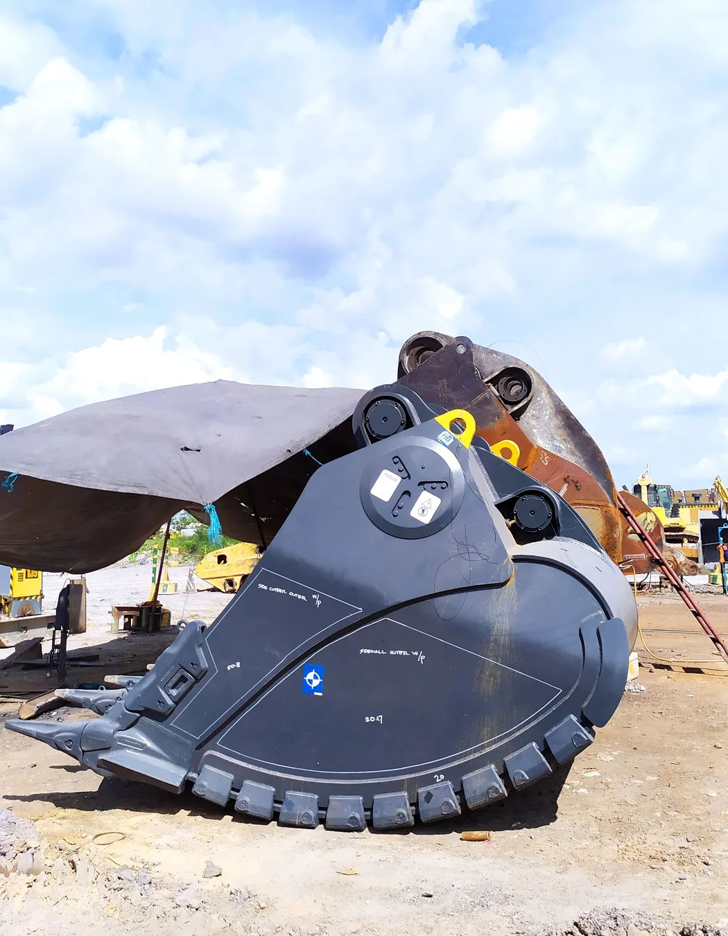 Large crusher bucket displayed on a construction equipment site for comparison with screening attachments