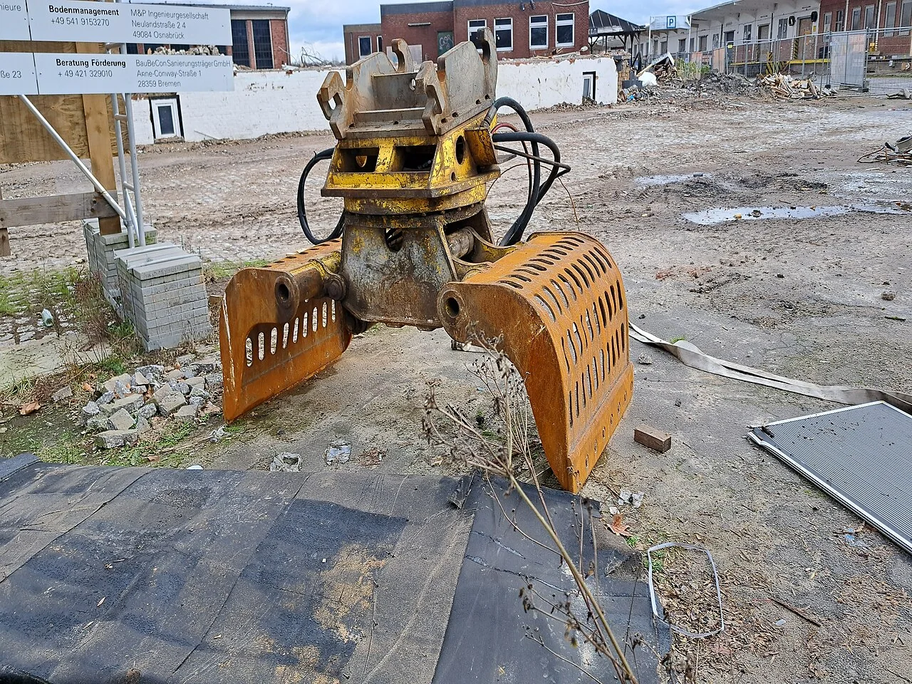 Close-up of a used rotating sorting grapple showing shells, rotator and hydraulic hoses