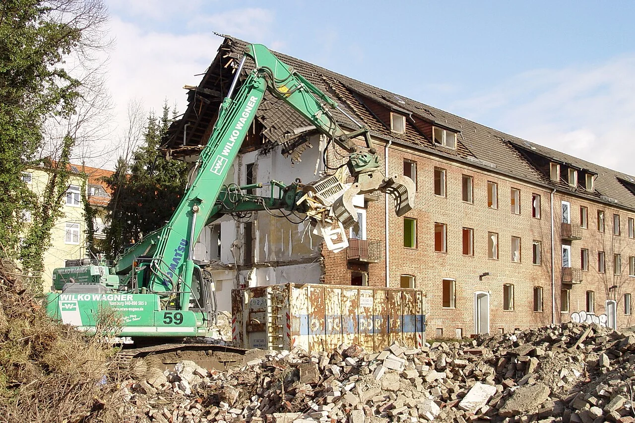 Excavator using a rotating sorting grapple during building demolition