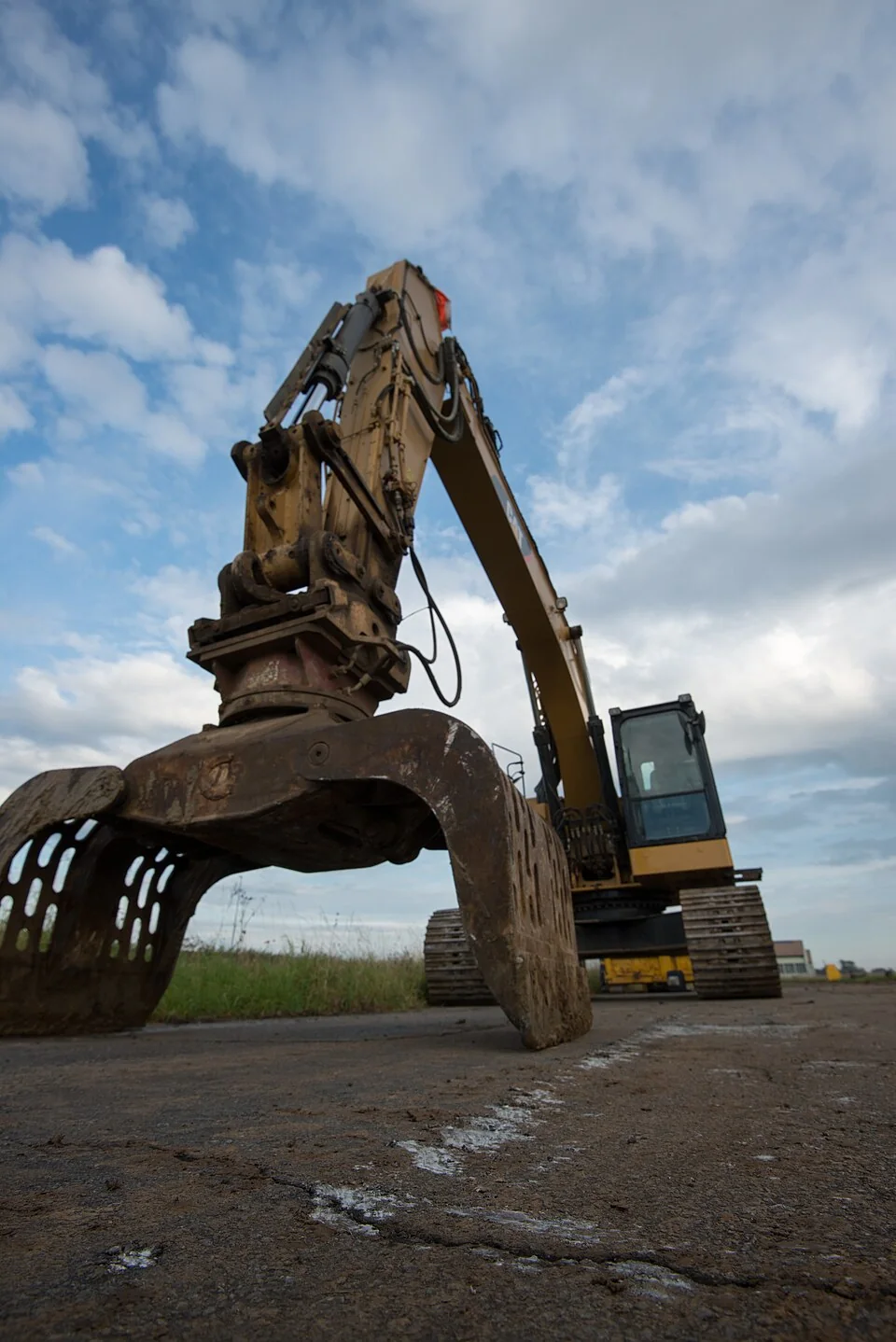 Low-angle view of a rotating sorting grapple and excavator prepared for recycling work