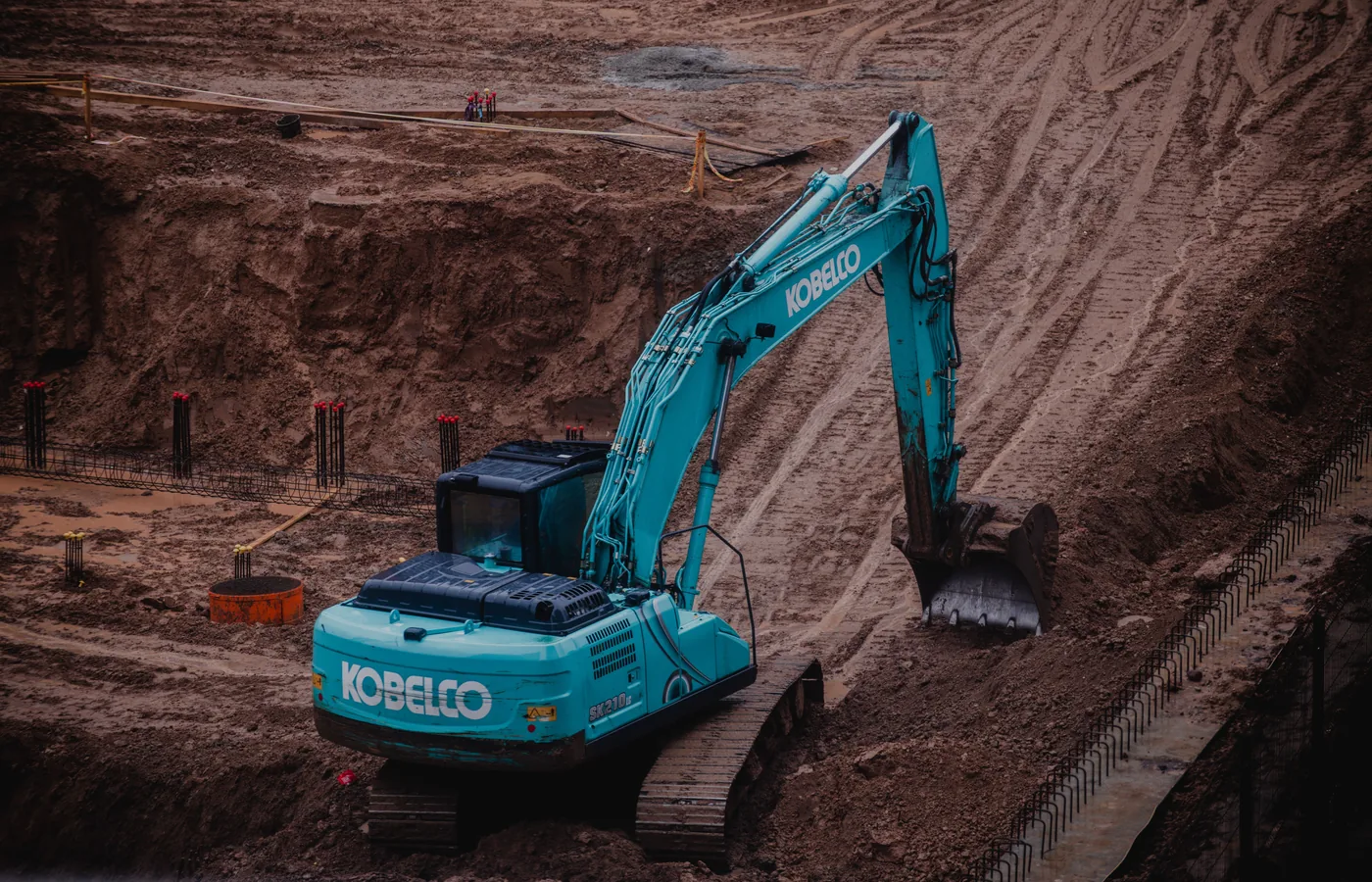 Tracked excavator digging in loose soft soil on an earthwork site