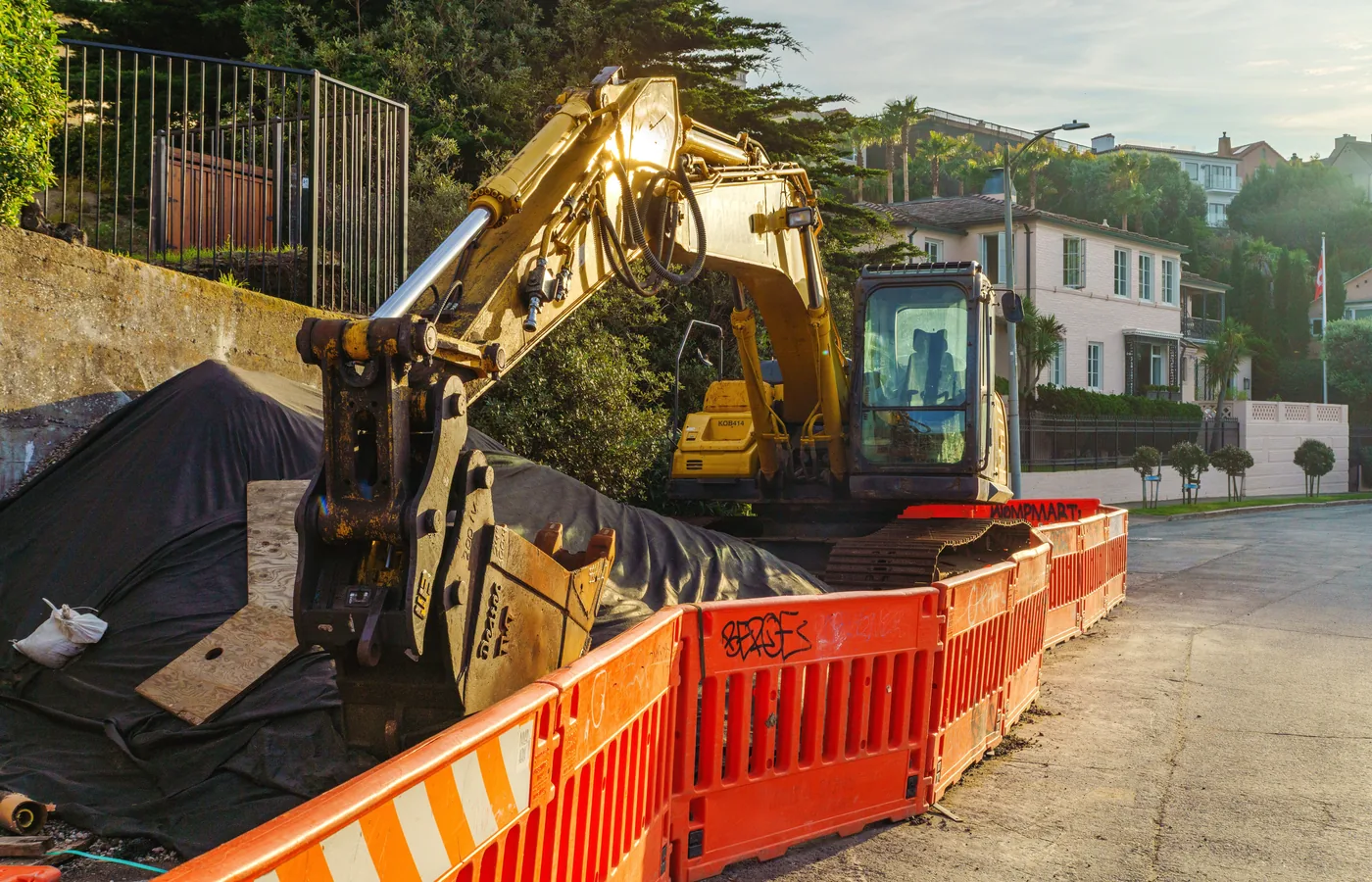 Compact excavator working inside a protected urban construction area